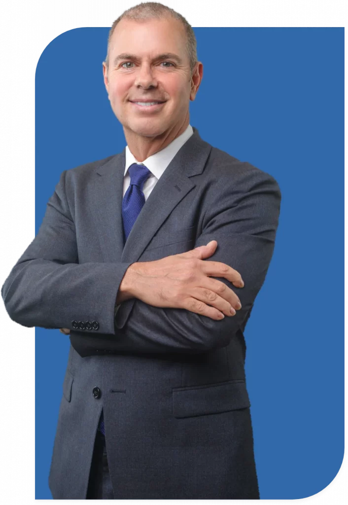 Professional man in a suit, smiling with arms crossed. Angel Reyes