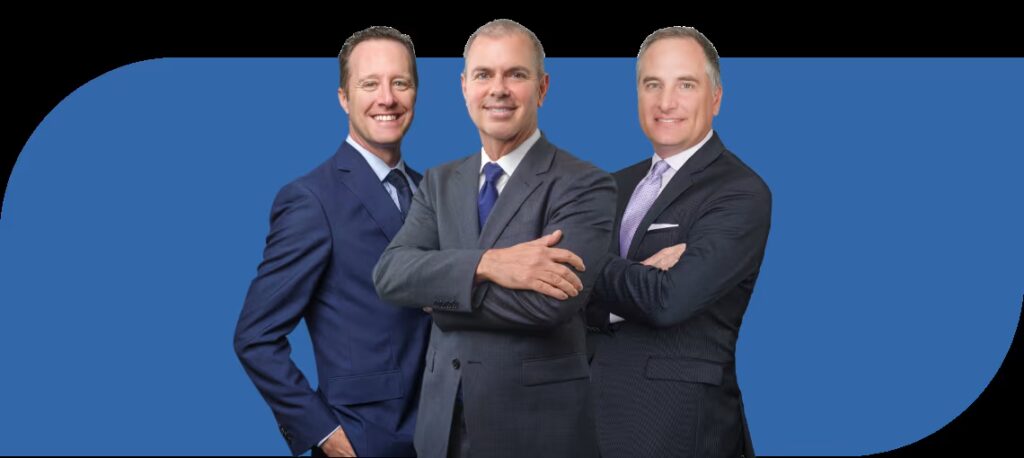 Three business professionals posing together against a blue background.