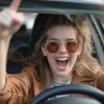 ChatGPT said:A young woman wearing sunglasses smiles and cheers while driving, with one hand on the wheel and the other raised.